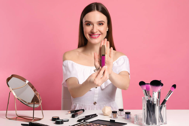 Beauty blogger showing lipgloss on pink background - Photo, image