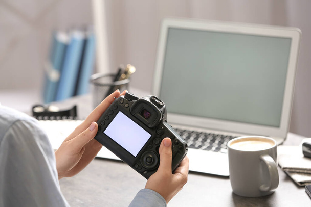 Journalist with camera at table in office, closeup - Foto, imagen