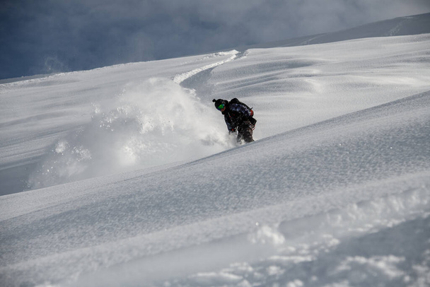 Freerider glides down the mountain side covered in snow - Foto, Bild