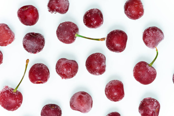 group of frozen cherries on a white background . the view from the top. ice crystals on the berry. vertical photo. close up - Foto, immagini