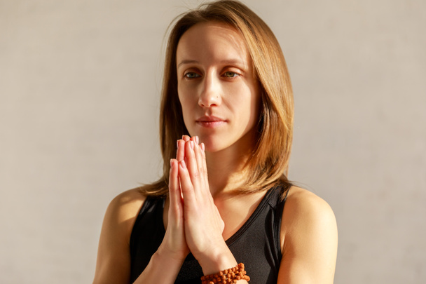 beautiful woman with praying hands in yoga studio  - Photo, Image