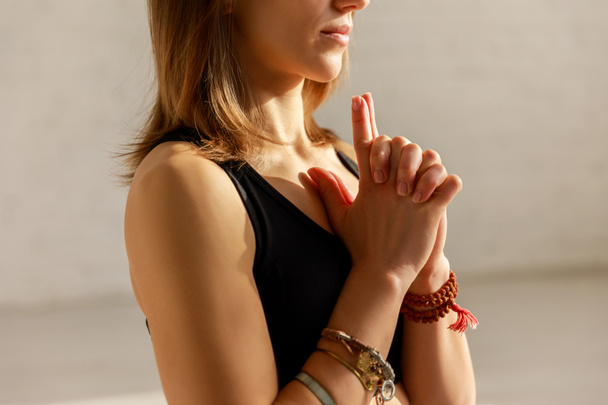 vista cortada da mulher com as mãos apertadas no estúdio de ioga
  - Foto, Imagem
