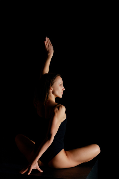 pretty woman in lotus pose practicing yoga isolated on black  - 写真・画像