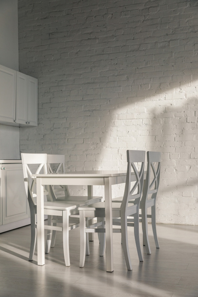 cadeiras e mesa perto da parede de tijolo na cozinha moderna
  - Foto, Imagem