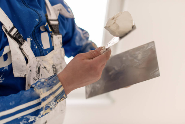 young professional construction worker plastering on gypsum walls inside the new big modern two levels apartment - Zdjęcie, obraz