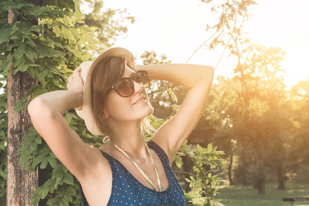 Nette junge Frau posiert draußen im sommerlichen Sonnenlicht. - Foto, Bild