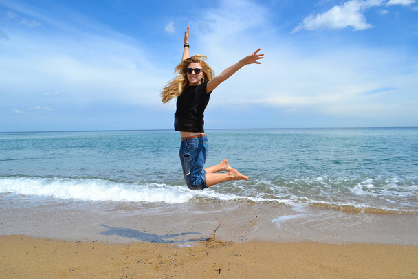 Ευτυχισμένη γυναίκα που πηδάει στην παραλία της Βαρκελώνης στην Ισπανία. Η ευτυχία και η επιτυχία. Έννοια Lgbt. - Φωτογραφία, εικόνα