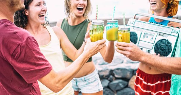 Junge Freunde mit Boombox-Party beim Beach-Sommerfest - Glückliche Meilensteine tanzen und trinken Cocktails zur Happy Hour beim Spring Break Event - Hippie-Lifestyle-Konzept auf Vintage-Filter - Foto, Bild