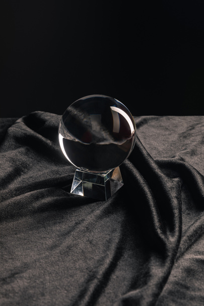 Crystal ball on fabric on black background - Photo, Image