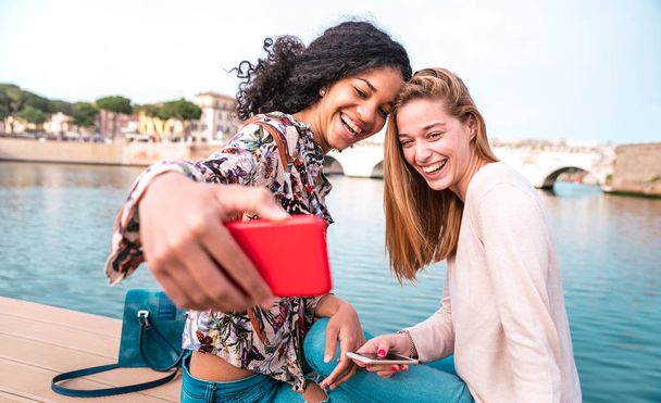 Multiethnic vriendinnen nemen selfie op stadspark samen - Vriendschap concept met gelukkige meisjes in de zomer stadsvakantie - Vrouwelijke levensstijl concept met millenial vrouwen influencer - Levendige filter - Foto, afbeelding
