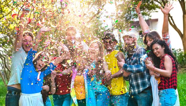 Šťastné vzrušené přátele baví venkovní oslavy s konfety - Mladí miléniové těší léto spolu na zahradní party - Veselé přátelství koncept na teplé živé filtrovaný barevný tón - Fotografie, Obrázek