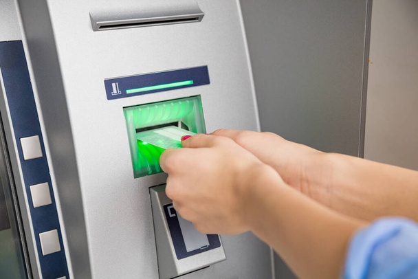 Frau benutzt modernen Geldautomaten - Bargeld abheben. - Foto, Bild