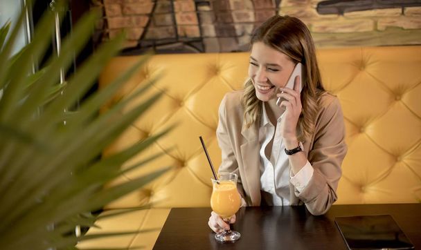 Okouzlující Yung žena pomocí mobilního telefonu v kavárně - Fotografie, Obrázek