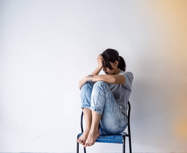 Samotna kobieta siedząca pod ścianą, nieszczęśliwe uczucie, zdenerwowana i wypróbowana, negatywne emocje, zespół zaburzeń depresyjnych - Zdjęcie, obraz