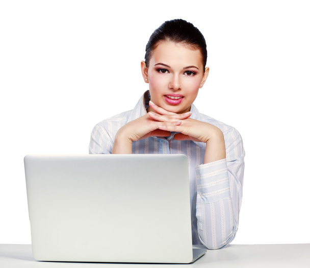 μια νεαρή γυναίκα που κάθεται με ένα φορητό υπολογιστή - Φωτογραφία, εικόνα