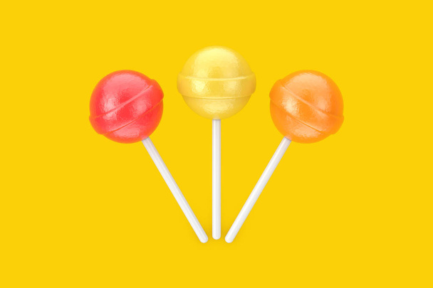Солодкі цукерки багатобарвні льодяники на жовтому тлі. 3D рендерингу
 - Фото, зображення