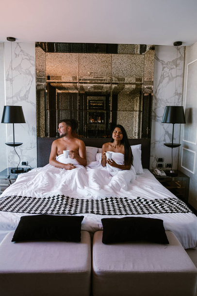 couple having breakfast in bed, men and woman in luxury room and white bed having breakfast in bed - Zdjęcie, obraz