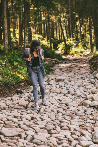woman with backpack hiking in forest by stone path trail travel concept - Photo, Image