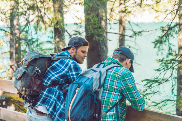 due giovani amici con backpackers a riposo durante le escursioni parlando tra loro
 - Foto, immagini
