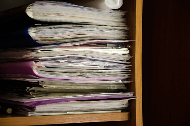 オフィスの食器棚の棚に書類がたくさんある。テキストの場所. - 写真・画像