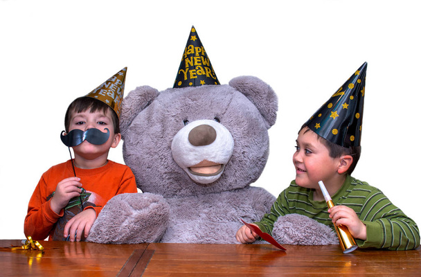 Αδέλφια και ένα μεγάλο αρκουδάκι γιορτάζουν την παραμονή της Πρωτοχρονιάς - Φωτογραφία, εικόνα