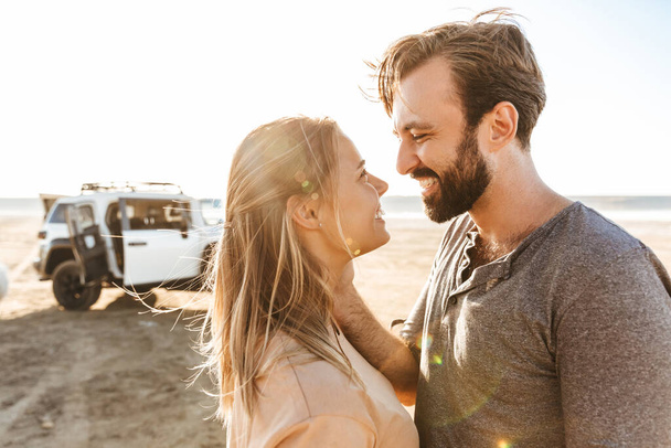 Image of happy optimistic cheerful young amazing loving couple outdoors at the beach. - Zdjęcie, obraz