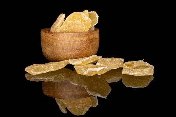 Lot of slices of dried yellow pineapple in bamboo bowl isolated on black glass - Foto, imagen