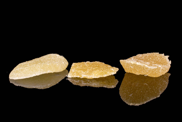 Group of three slices of dried yellow pineapple isolated on black glass - Фото, изображение