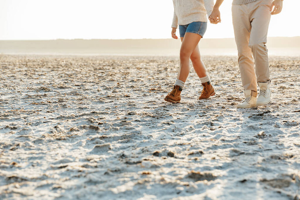 Vágott fénykép fiatal szerető pár szabadban a strandon séta. - Fotó, kép