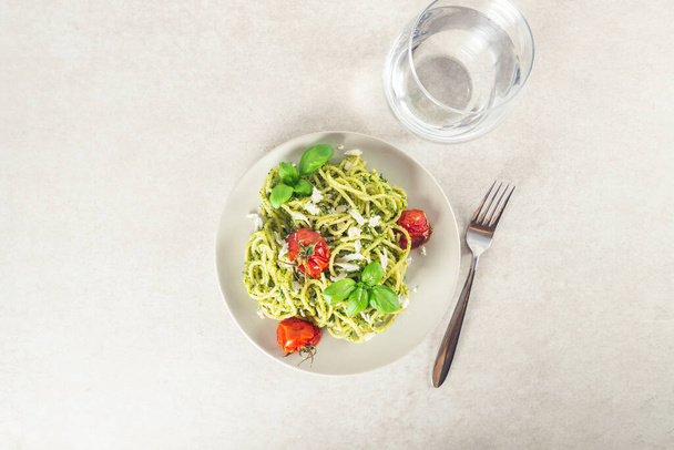 Pasta spaghetti with homemade pesto sauce, roasted tomatoes and fresh basil leaves, vegetarian food - Photo, image