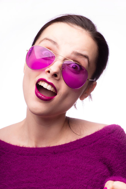 Mädchen im lila Pullover, lila Brille mit lila Lippenstift auf den Lippen - Foto, Bild