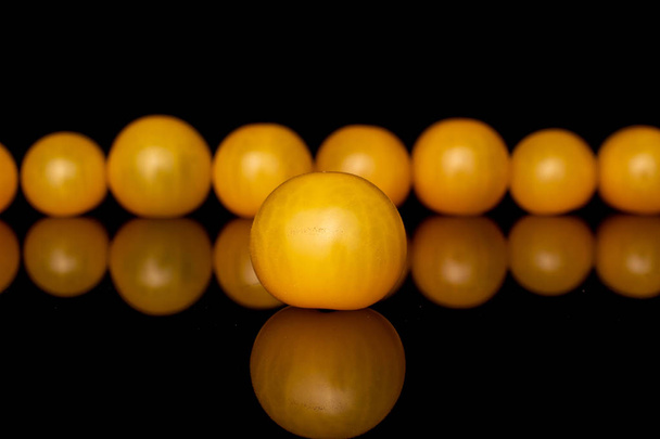 Group of nine whole fresh yellow tomato isolated on black glass - Fotó, kép