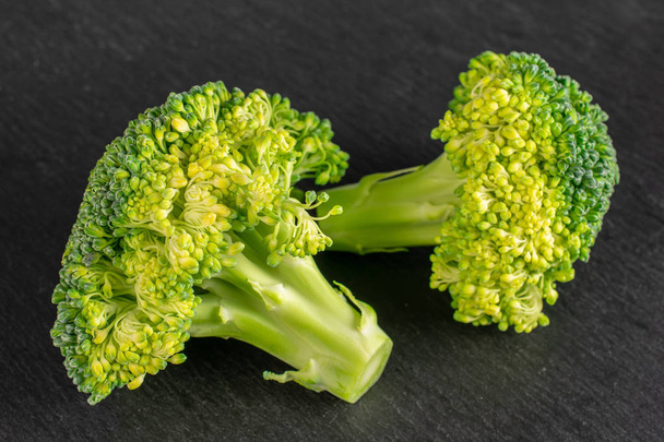 Group of two whole fresh green broccoli head on grey stone - Zdjęcie, obraz
