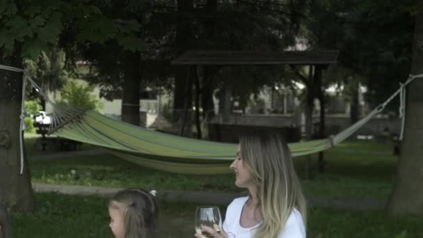 Happy families doing picnic outdoor sitting on meadow. Parents and children having fun on weekend day in public park eating and drinking Positive mood, parenthood, childhood. - Materiał filmowy, wideo