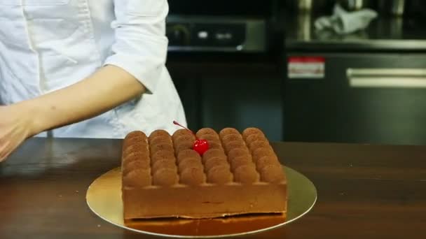 confectioner show original creamy mousse cake with chocolate topping and cherry - Video, Çekim