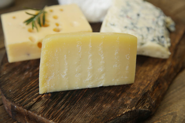 Tahta bir tahtanın üzerinde parmesan peyniri ve peynir. Organik tarım süt ürünleri - Fotoğraf, Görsel