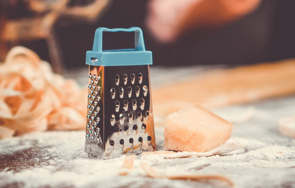 Small cheese grater and piece of cheese closeup on the cusine table - Fotografie, Obrázek