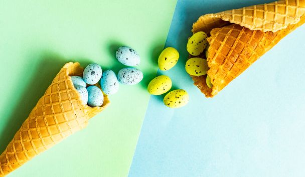 Easter card concept with waffle cone full of easter eggs  pastel color background with copy space - Photo, image