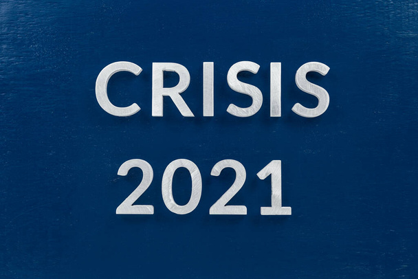 the words crisis 2021 laid with silver metal letters on blue surface for stock market background - Фото, изображение