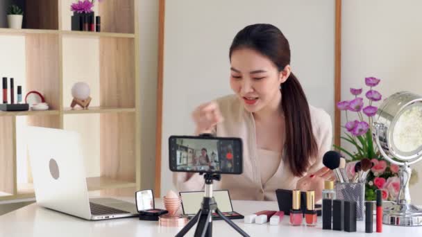 4k Video des berühmten Bloggers. Fröhliche Vloggerin zeigt Kosmetikprodukte, während sie Videos für das alltägliche Make-up-Tutorial aufnimmt. bei der Arbeit. - Filmmaterial, Video