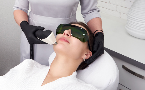 Młoda kobieta leczona laserowo w klinice kosmetologii - Zdjęcie, obraz