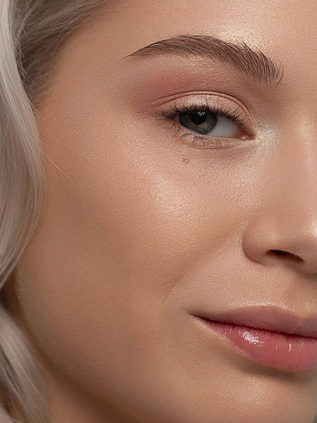 Closeup of half beauty woman with clean skin and natural cosmetics. Beautiful extrem eyelash and full lips of well-groomed girl demonstrate spa procedures, injections in a beauty parlor. Blonde hair - Φωτογραφία, εικόνα