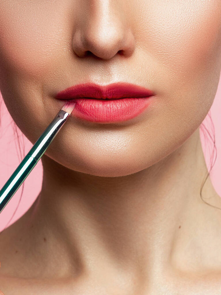 Woman painted pink lips. Beauty lips make-up. Perfect skin, full lips. Retro make up. Professional make-up artist applying sexy lips makeup. Fashion makeup - Fotoğraf, Görsel