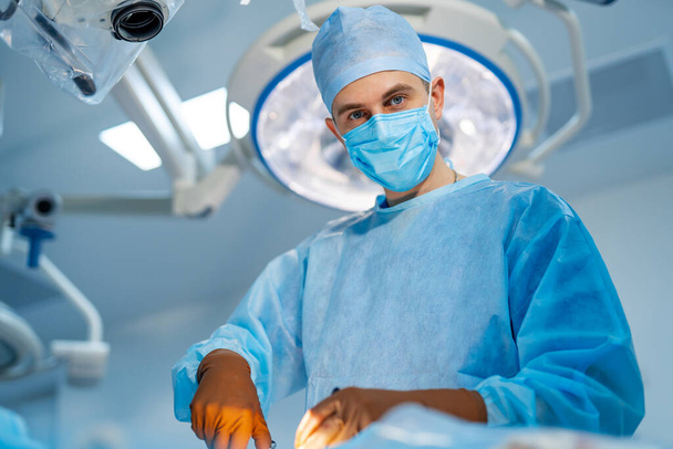 Surgeon in operating room with surgery equipment. Medical team performing operation. - Foto, immagini
