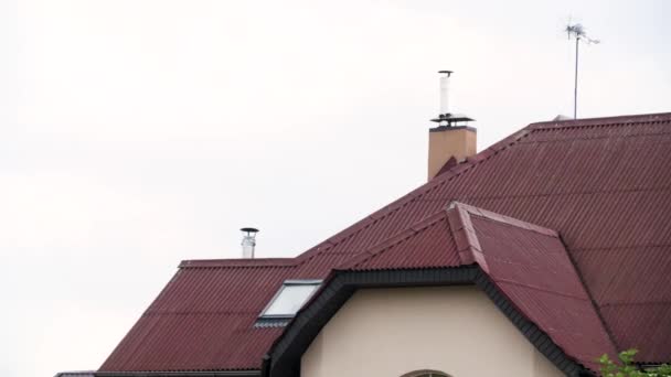 Krásná střecha městského domu s červenými střešními taškami na zakaleném pozadí oblohy. Akciová fotáž. Fasáda nového obytného domu, architektonický koncept. - Záběry, video