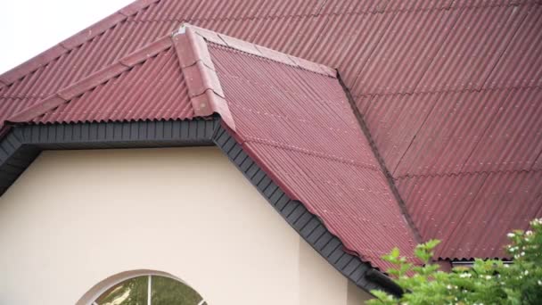 Krásná střecha městského domu s červenými střešními taškami na zakaleném pozadí oblohy. Akciová fotáž. Fasáda nového obytného domu, architektonický koncept. - Záběry, video