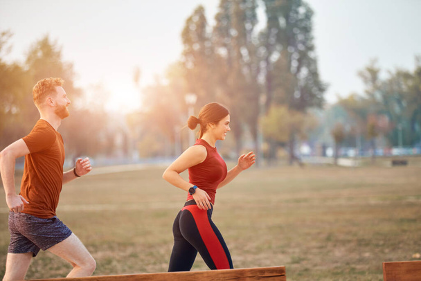 Modern nő és férfi kocogás / testmozgás a városi parkban. - Fotó, kép