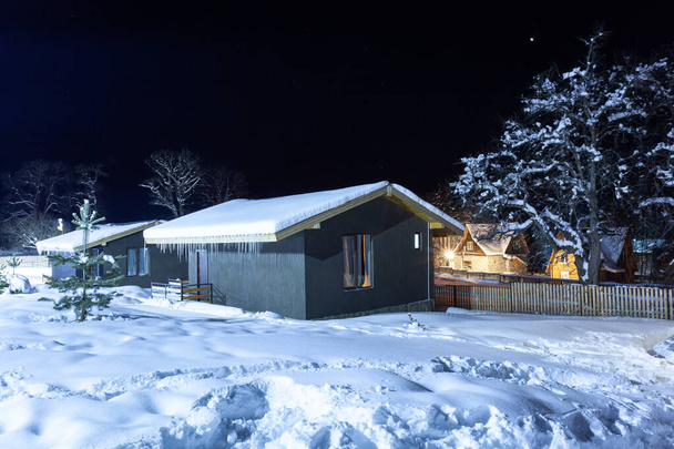 Vakantiehuisjes in het winterresort Bakuriani 's nachts. Georgië - Foto, afbeelding