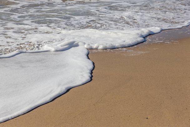 Мягкая морская волна катится на песок пляжа. Морские волны на побережье
 - Фото, изображение