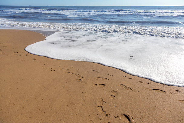 柔らかい海の波がビーチの砂の上を転がっている。海岸沿いの波景 - 写真・画像